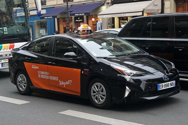Taxi parisien en circulation dans une rue de Paris, illustration du parc taxi français en transition vers l’électrique
