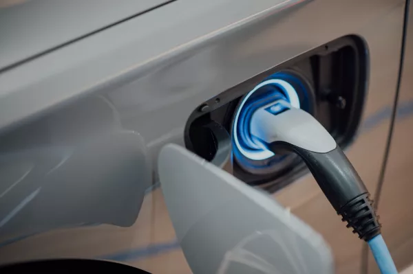 Voiture électrique en charge sur une borne rapide, illustrant le coût de la recharge