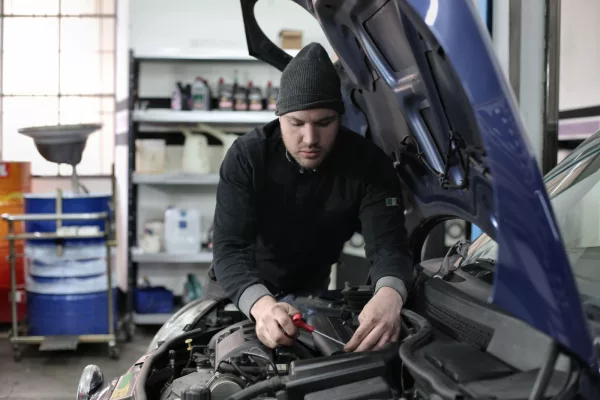 Mécanicien travaillant sur la transmission d'une voiture en atelier
