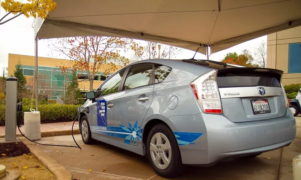 Toyota Prius hybride rechargeable en cours de charge, câble branché sur le véhicule
